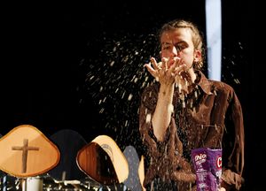 Puppenspielerin, die Popkorn in Richtung des Betrachters von ihrer Hand in die Luft pustet 