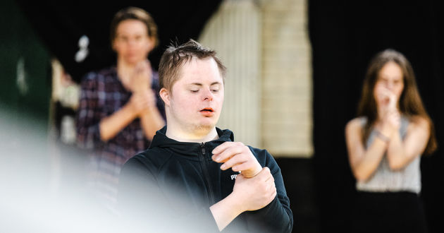 Der Schauspieler Jonas Sippel steht auf der Bühne des RambaZamba-Theaters und leitet eine Übung zum Aufwärmen an.